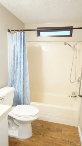 an empty room with wooden floor and window