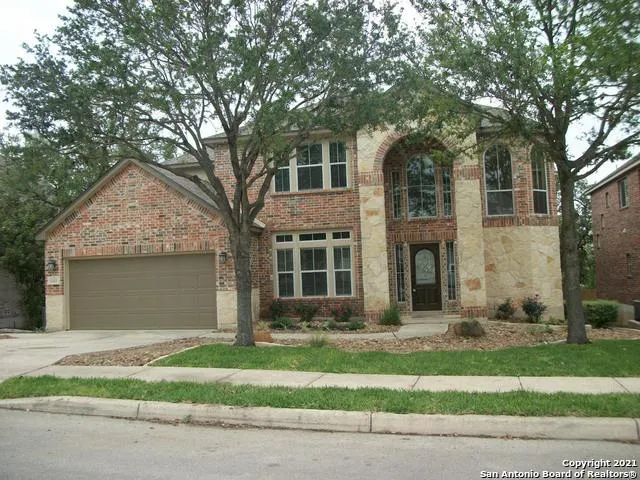 a front view of a house with a garden and tree