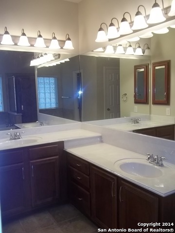 16202 Juan Tabo Way Helotes, TX 78023 - Photo 13 of 22 a bathroom with a sink double vanity and a mirror