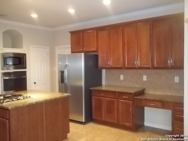 16202 Juan Tabo Way Helotes, TX 78023 - Photo 6 of 22 a kitchen with stainless steel appliances granite countertop a refrigerator and a stove top oven