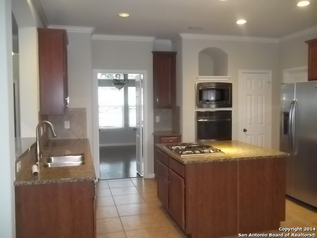 16202 Juan Tabo Way Helotes, TX 78023 - Photo 7 of 22 a kitchen with stainless steel appliances granite countertop a sink stove and refrigerator