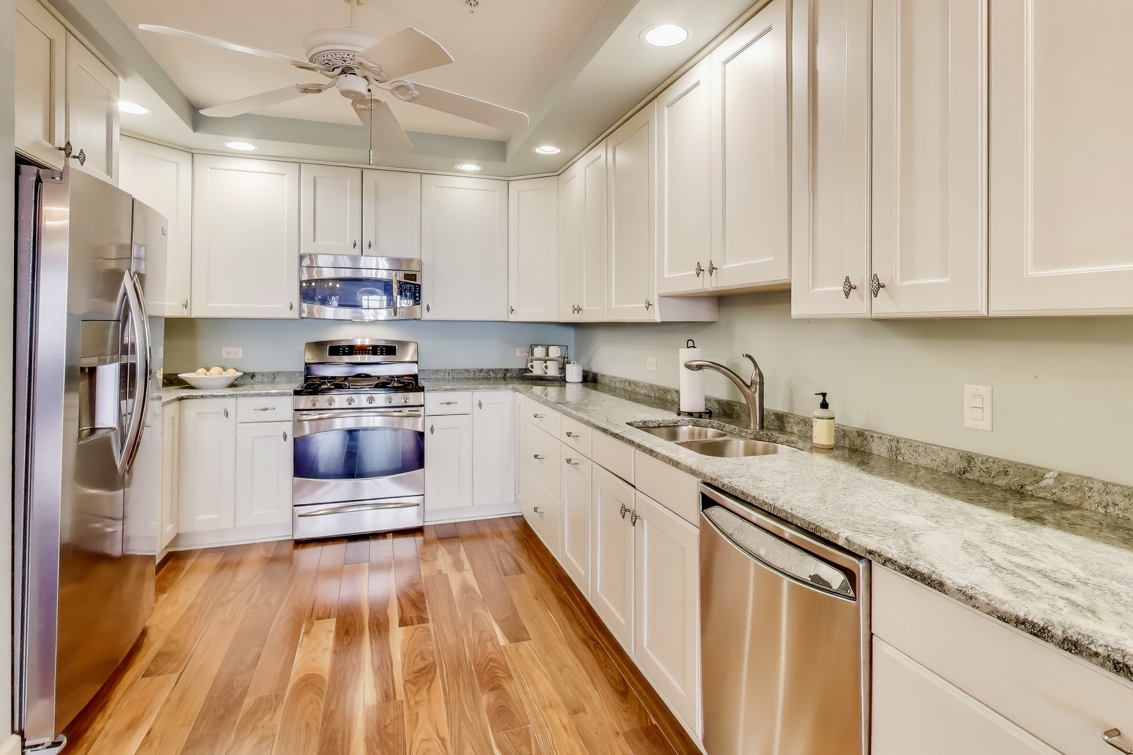 10 East Burlington Street, Unit 2C Riverside, IL 60546 - Photo 7 of 46 a kitchen with kitchen island granite countertop a sink cabinets and stainless steel appliances