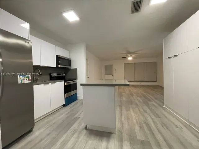 a kitchen with a refrigerator and a stove top oven
