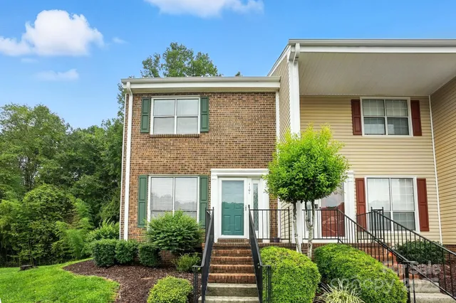 a front view of a house with plants and garden