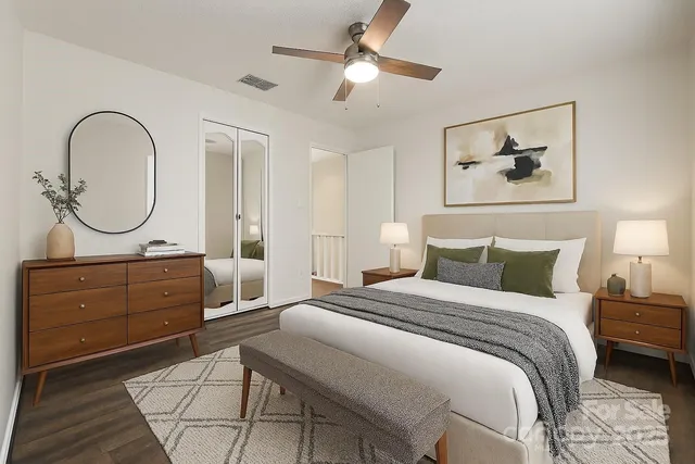 a bedroom with a bed a chandelier and a dresser