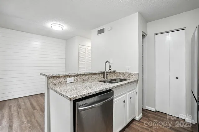 a kitchen with a granite countertop sink and white cabinets