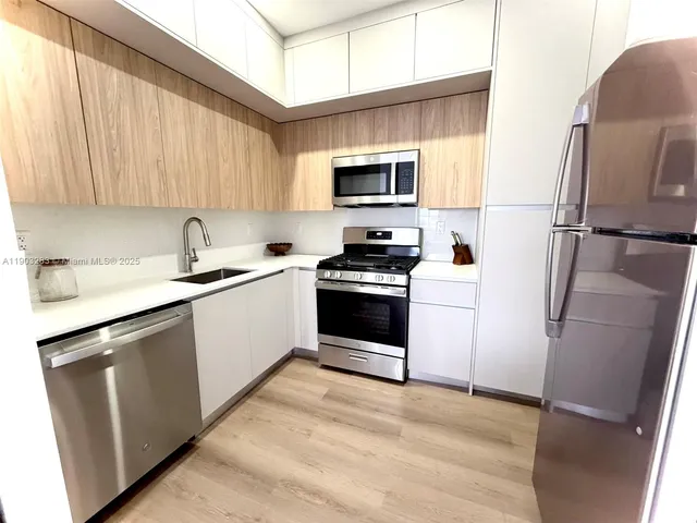 a kitchen with stainless steel appliances a refrigerator sink and microwave
