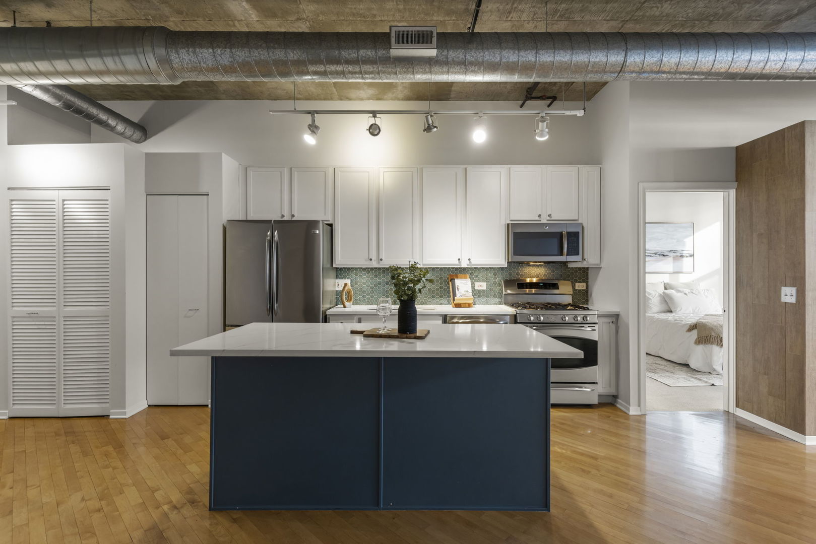1000 West Adams Street, Unit 302 Chicago, IL 60607 - Photo 6 of 19 a kitchen with stainless steel appliances kitchen island granite countertop a refrigerator a stove and a sink