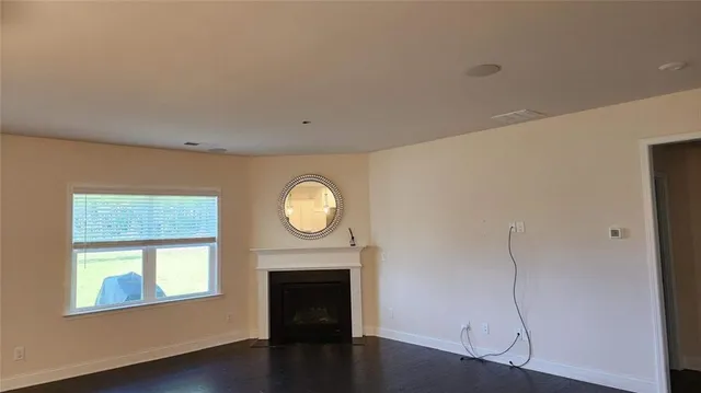 a view of a livingroom with wooden floor and a large window