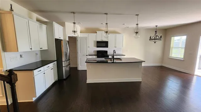 a kitchen with stainless steel appliances a refrigerator sink and white cabinets