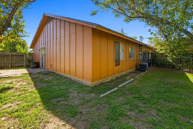 a view of yard with green space and trees in the background