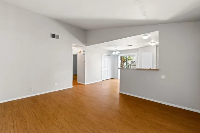 a view of an empty room with wooden floor