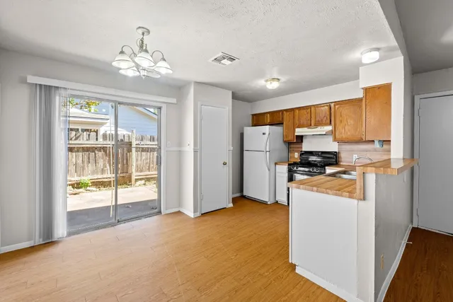 a view of kitchen with stainless steel appliances kitchen island refrigerator stove and sink