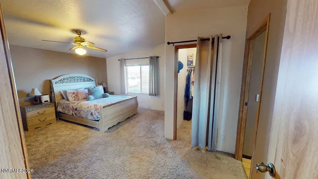 a spacious bedroom with a bed a mirror and a window