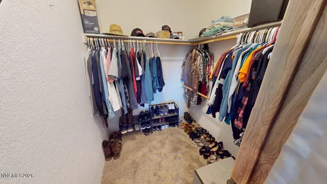 a view of walk in closet with clothes and shoes