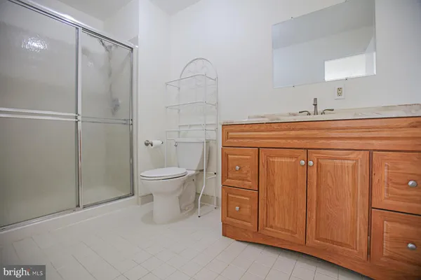 a spacious bathroom with a granite countertop sink toilet and shower