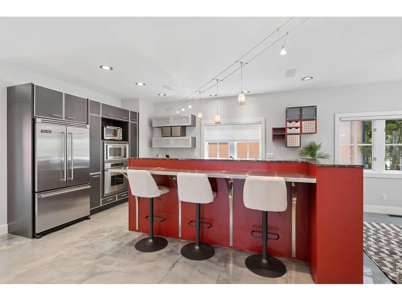 821 Incorrigible Circle Longmont, CO 80504 - Photo 12 of 43 a kitchen with stainless steel appliances kitchen island granite countertop a dining table chairs and granite counter tops