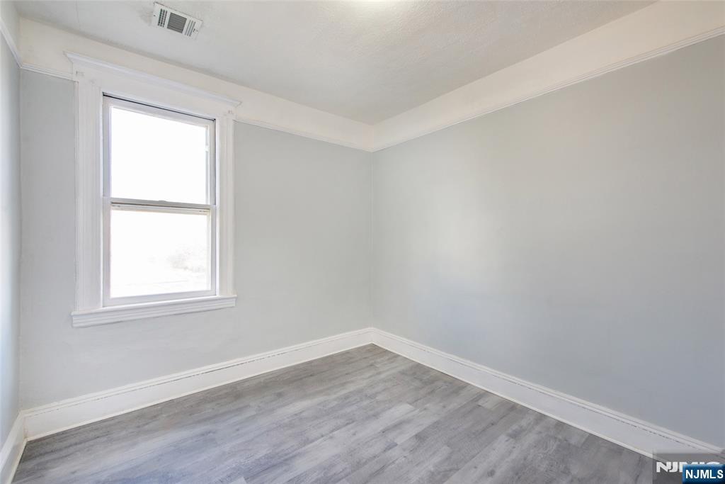 51 Maple Street Garfield, NJ 07026 - Photo 11 of 12 an empty room with wooden floor and windows