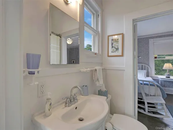 a bathroom with a toilet a sink and mirror