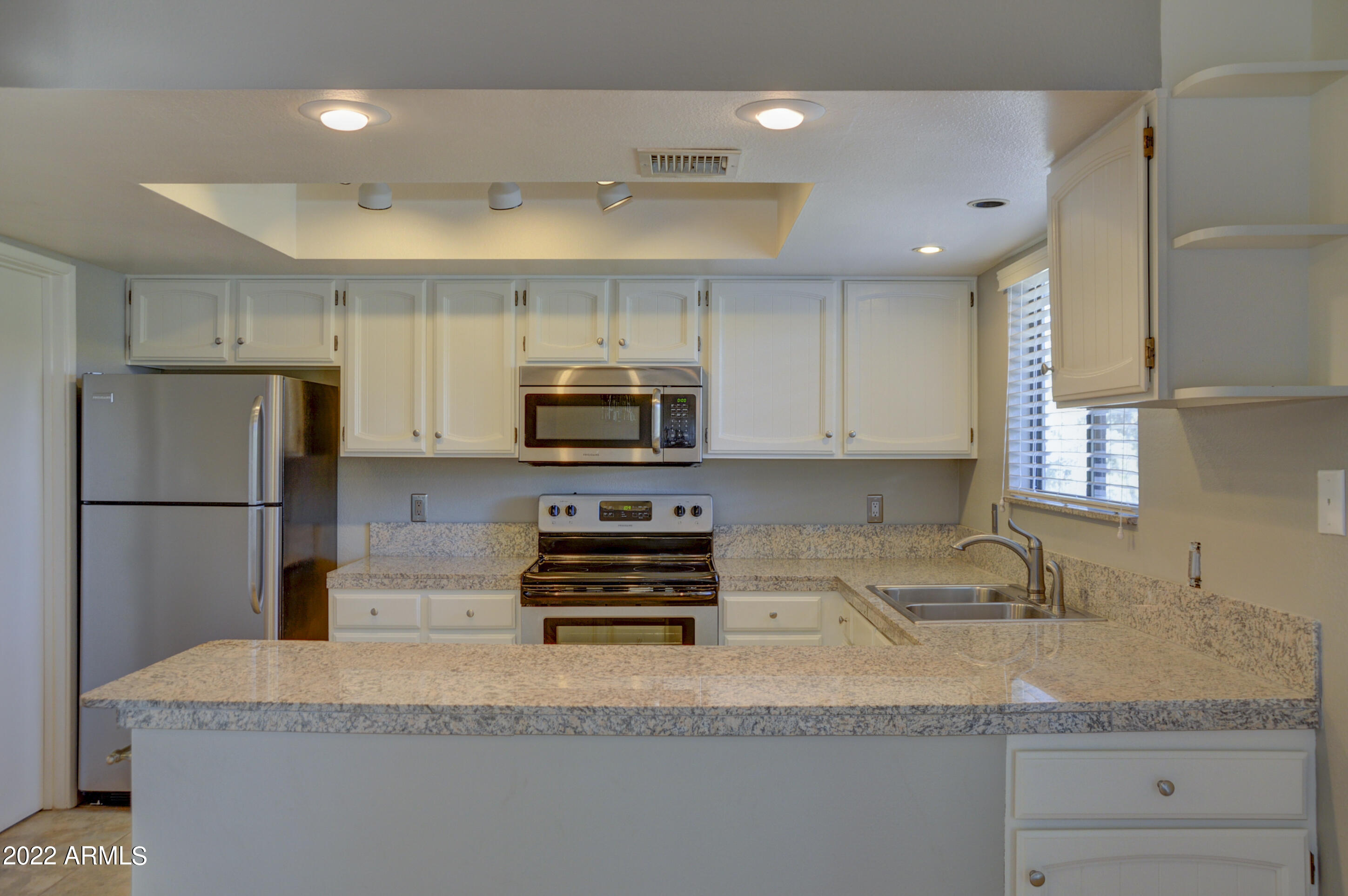 685 Dragonfly Drive Prescott, AZ 86301 - Photo 8 of 24 a kitchen with stainless steel appliances granite countertop a sink a stove a refrigerator a microwave and cabinets