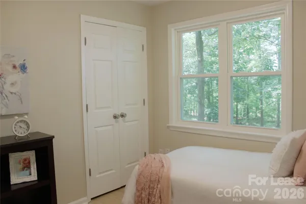 a bed sitting in a bedroom next to a window