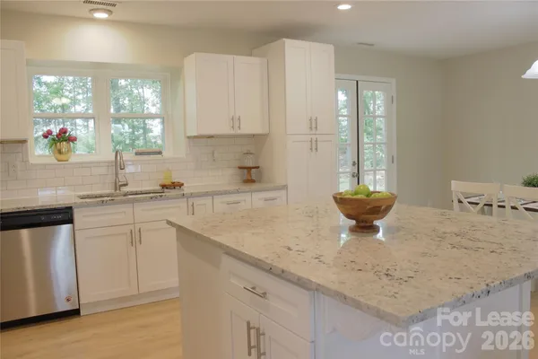 a kitchen with a sink a window and cabinets