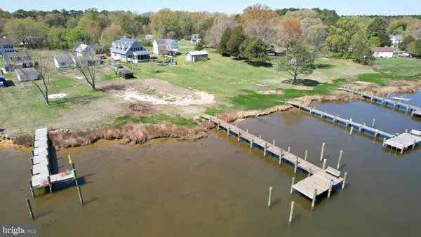 an aerial view of a house with a yard and lake view