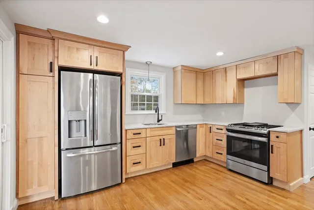 a kitchen with stainless steel appliances a refrigerator sink and cabinets