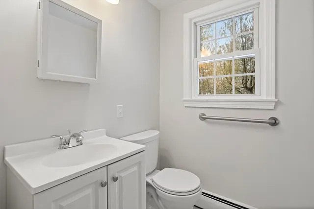 a bathroom with a sink a toilet and a window