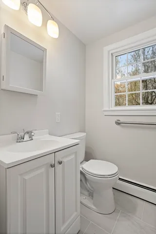 a bathroom with a toilet sink and mirror