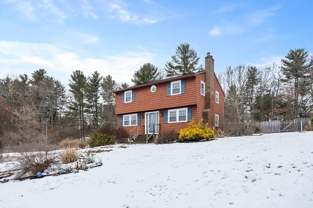 a front view of a house with a yard covered in snow