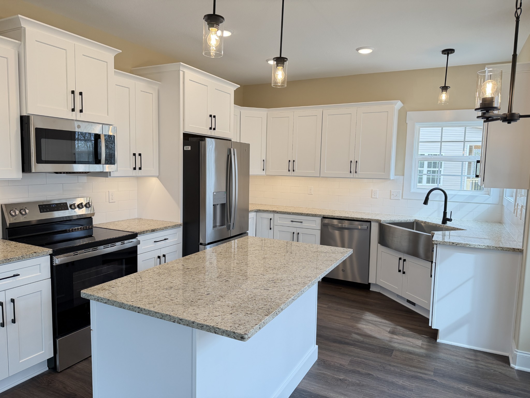 128 Hummingbird Way Clarksville, TN 37043 - Photo 3 of 19 a large kitchen with stainless steel appliances a stove a sink dishwasher a refrigerator white cabinets and wooden floor