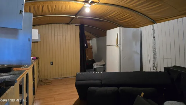 a view of a room with furniture and wooden floor