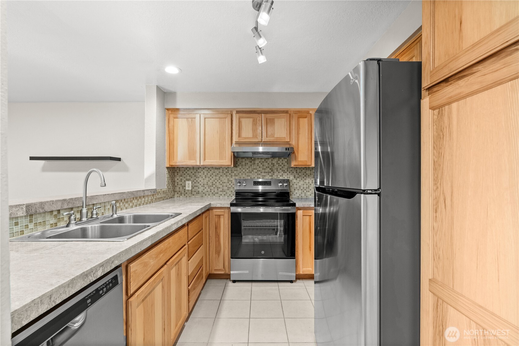 1321 South Puget Drive, Unit E15 Renton, WA 98055 - Photo 12 of 30 a kitchen with stainless steel appliances granite countertop a sink stove and refrigerator