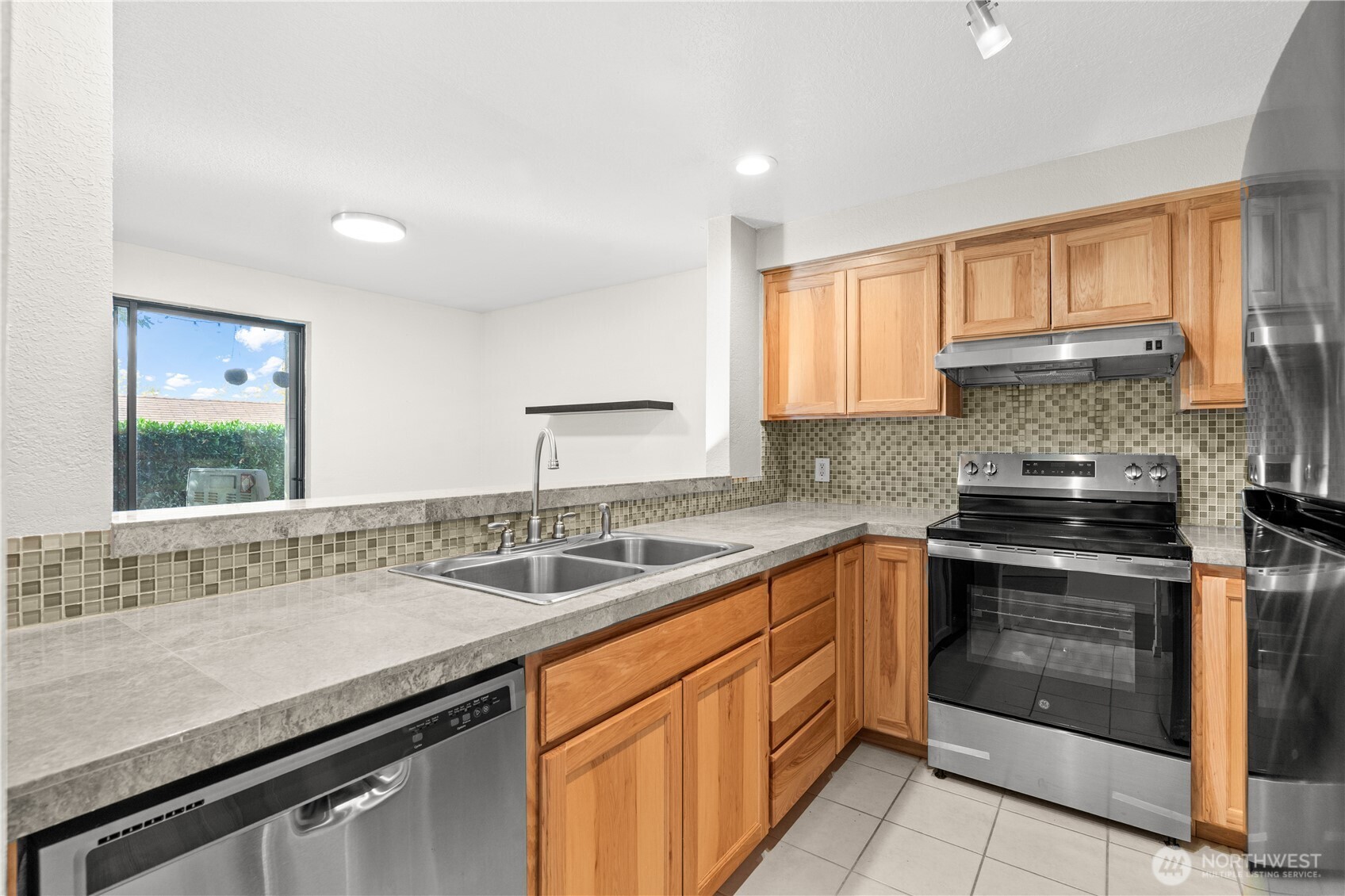 1321 South Puget Drive, Unit E15 Renton, WA 98055 - Photo 13 of 30 a kitchen with stainless steel appliances granite countertop a sink stove and cabinets