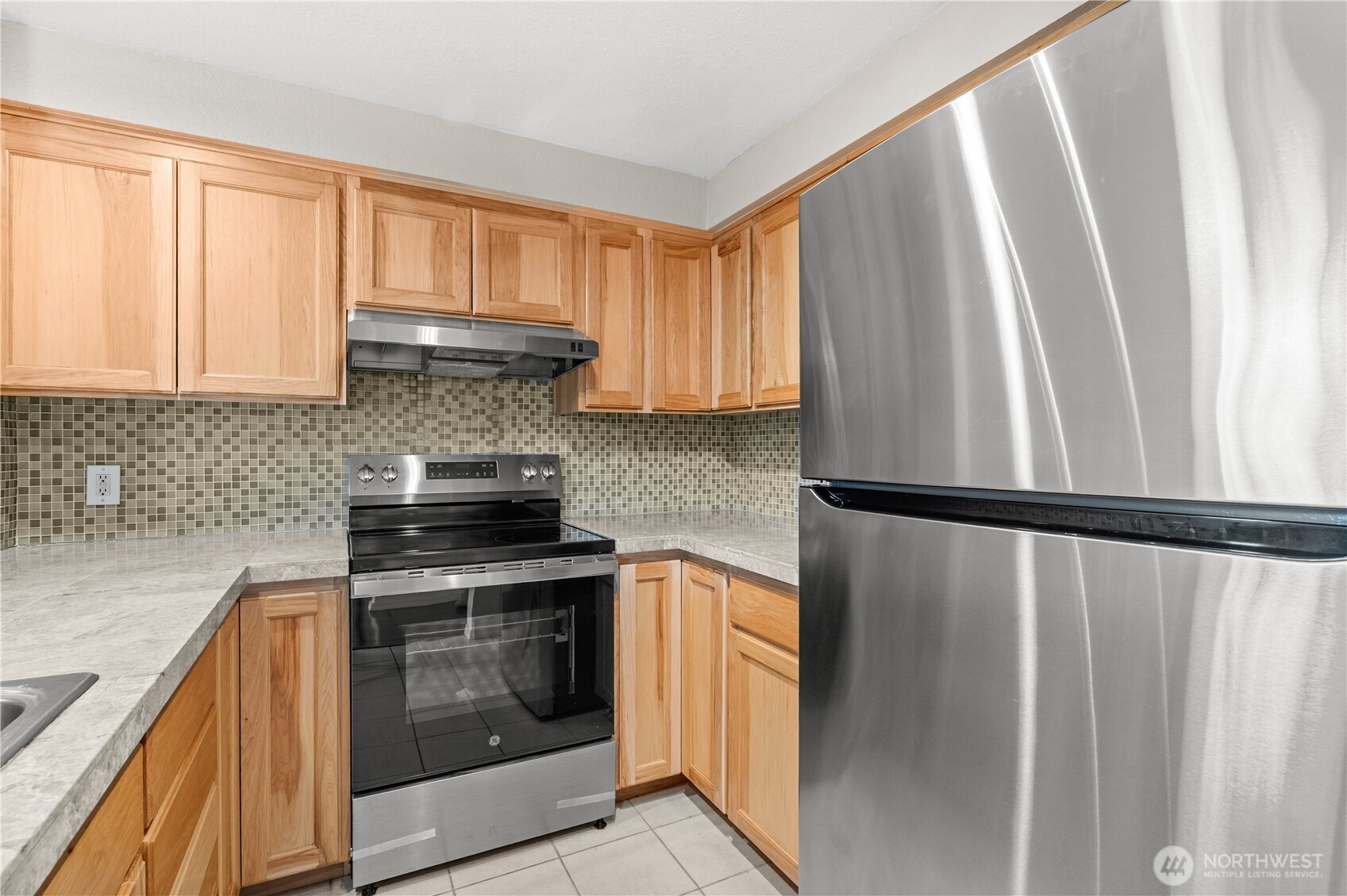 1321 South Puget Drive, Unit E15 Renton, WA 98055 - Photo 14 of 30 a kitchen with a stove a fridge and a sink