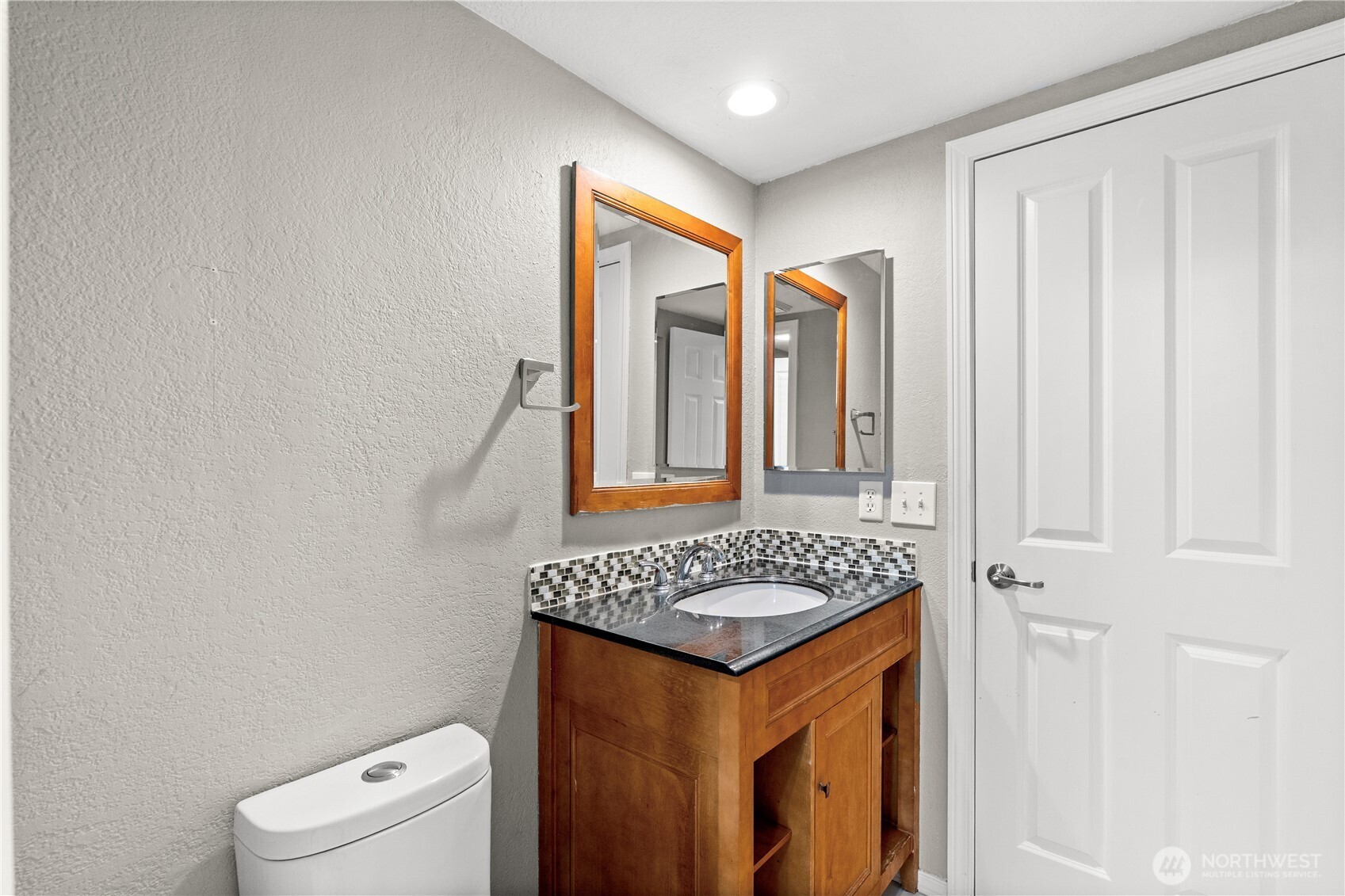 1321 South Puget Drive, Unit E15 Renton, WA 98055 - Photo 19 of 30 a bathroom with a granite countertop sink and a mirror