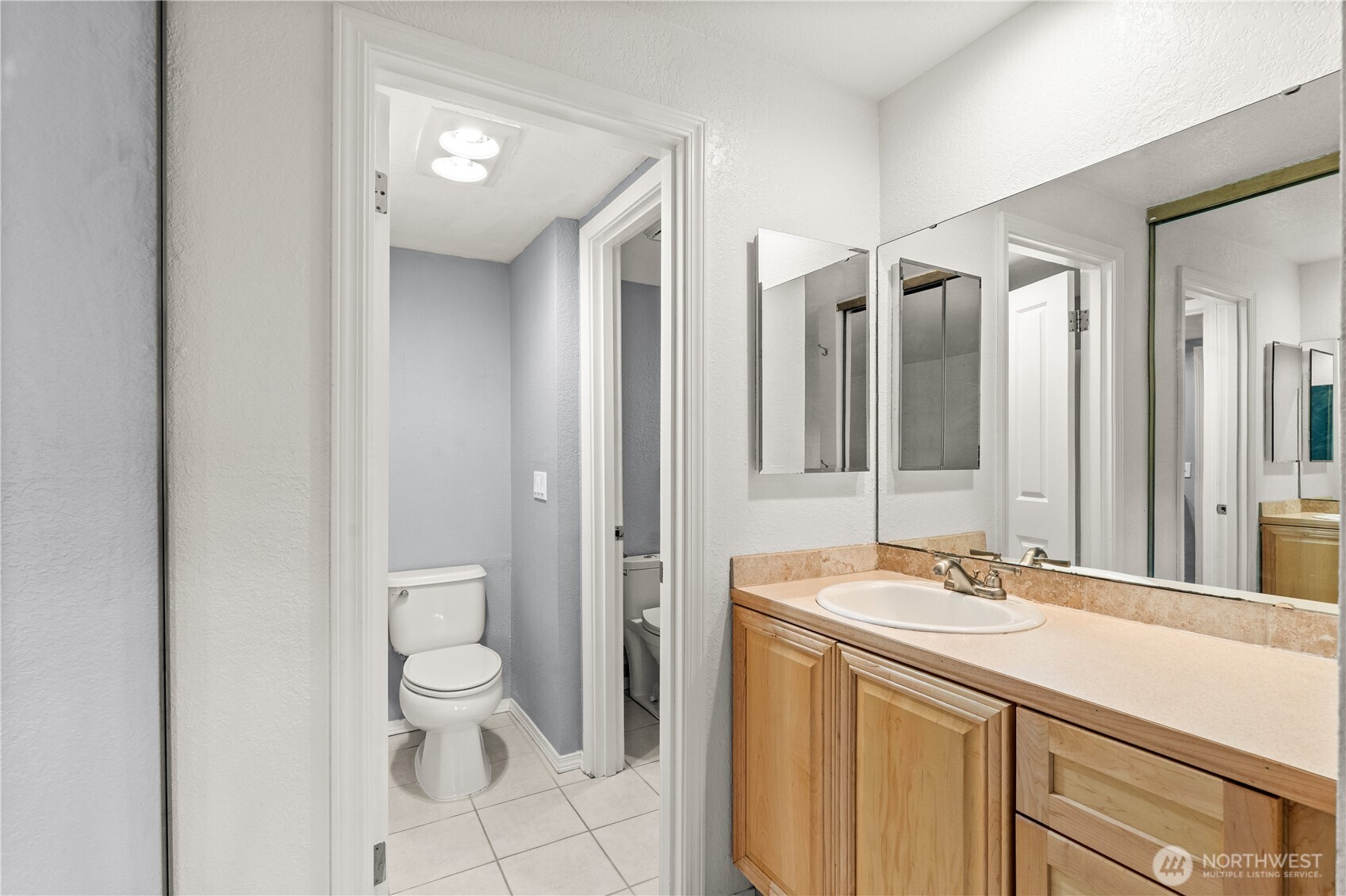 1321 South Puget Drive, Unit E15 Renton, WA 98055 - Photo 24 of 30 a bathroom with a sink a toilet and a mirror