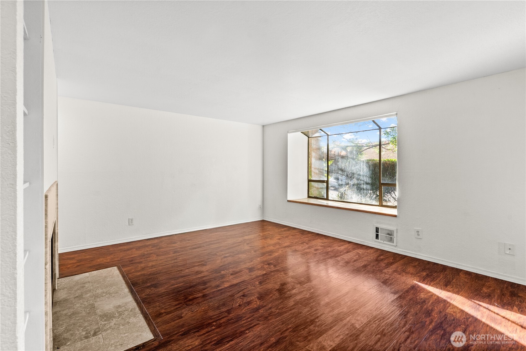1321 South Puget Drive, Unit E15 Renton, WA 98055 - Photo 4 of 30 an empty room with wooden floor and windows