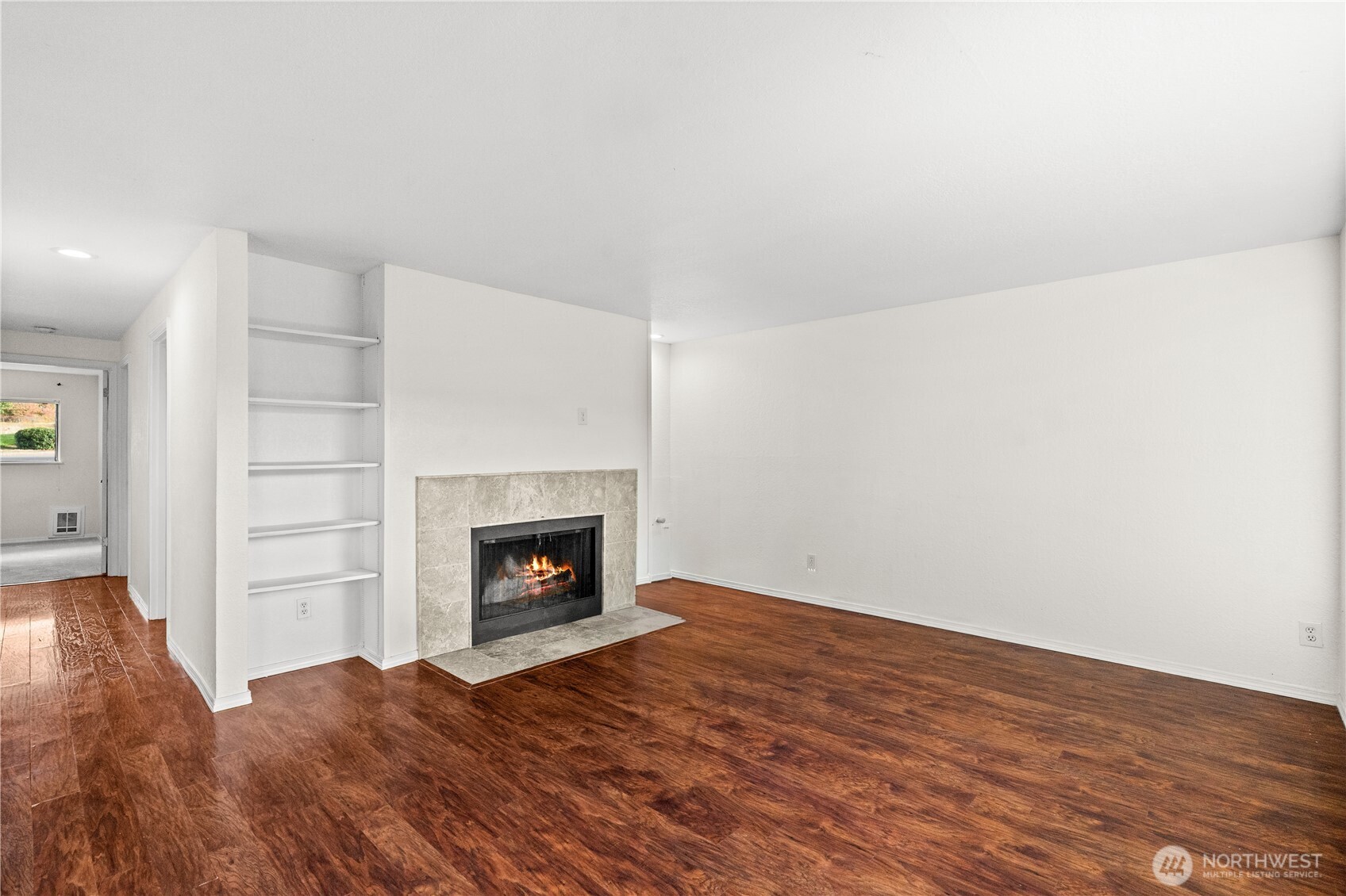 1321 South Puget Drive, Unit E15 Renton, WA 98055 - Photo 5 of 30 a view of an empty room with wooden floor fireplace and a window