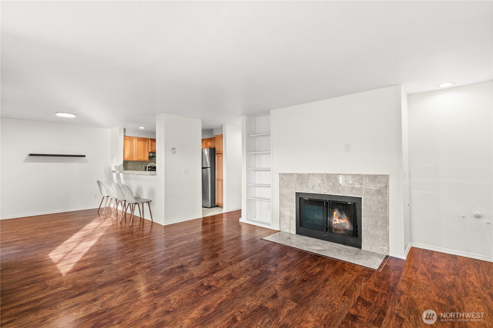 1321 South Puget Drive, Unit E15 Renton, WA 98055 - Photo 6 of 30 a view of an empty room with wooden floor fireplace and a window