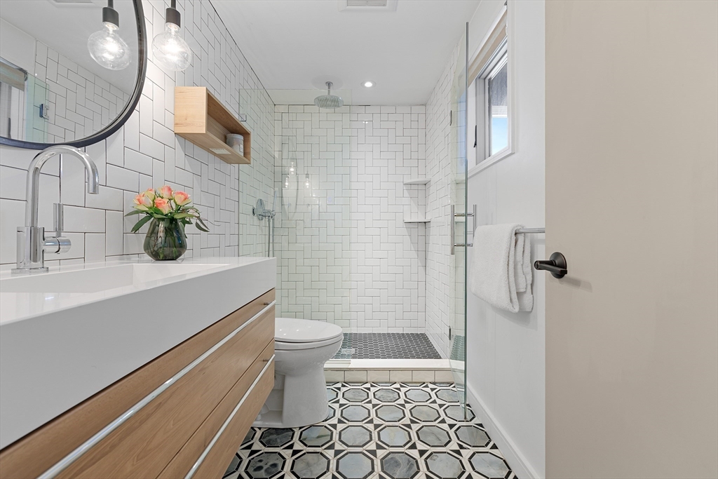 23 Pinecliff Drive Marblehead, MA 01945 - Photo 24 of 41 a bathroom with a sink a toilet a mirror and shower