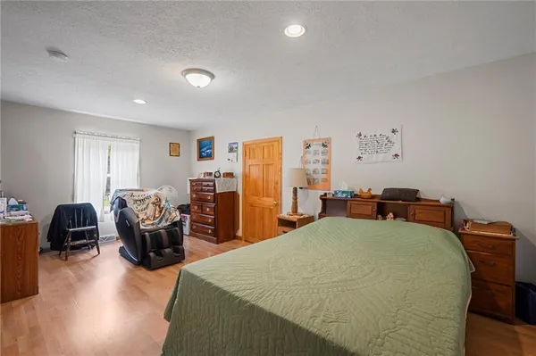a bedroom with a bed a couch and dresser