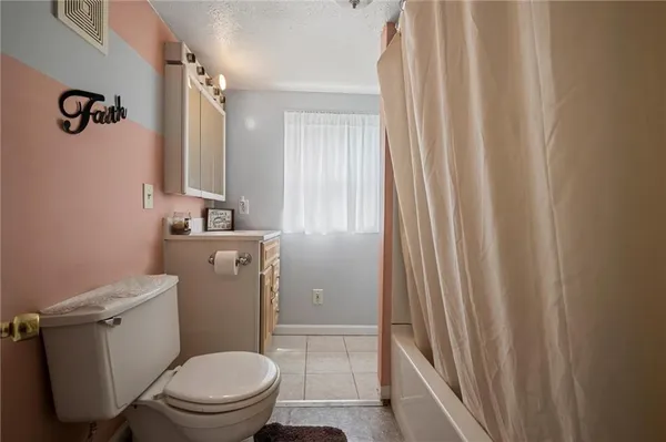 a white toilet sitting next to a shower curtain