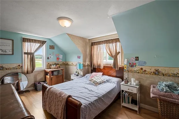 a bedroom with a bed and large windows