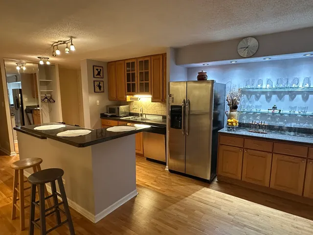 a kitchen with stainless steel appliances granite countertop a refrigerator and a stove