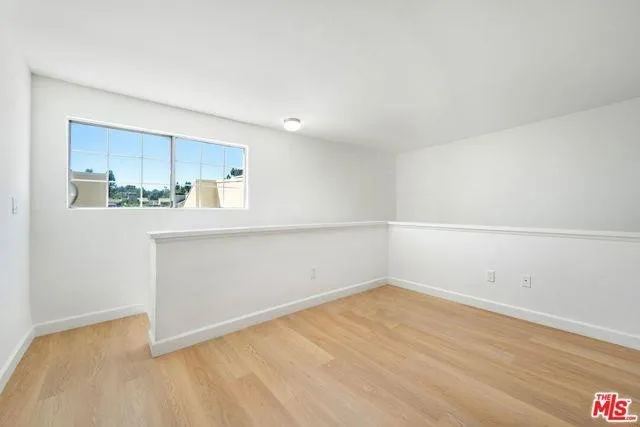 a view of a backyard with lawn chairs potted plants and palm tree