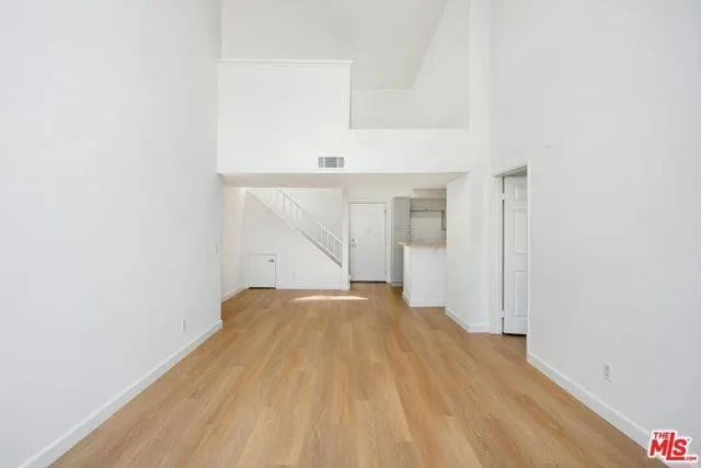 a view of a kitchen with a sink dishwasher oven window and wooden floor