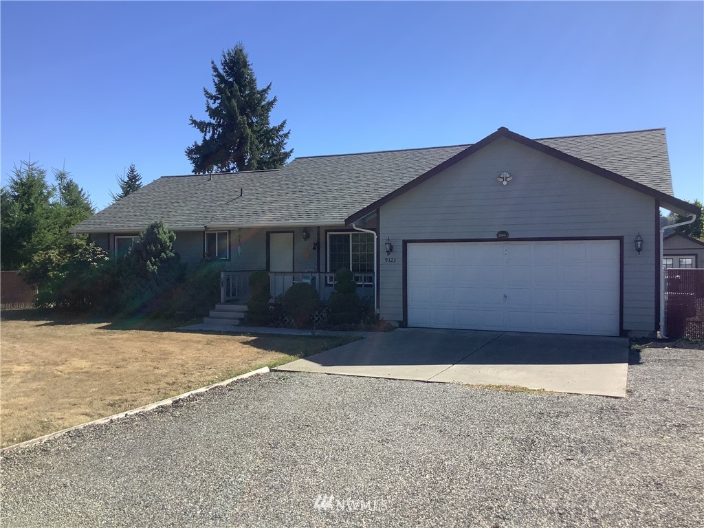9323 180th Way Southwest Rochester, WA 98579 - Photo 1 of 33 a front view of a house with a yard and garage