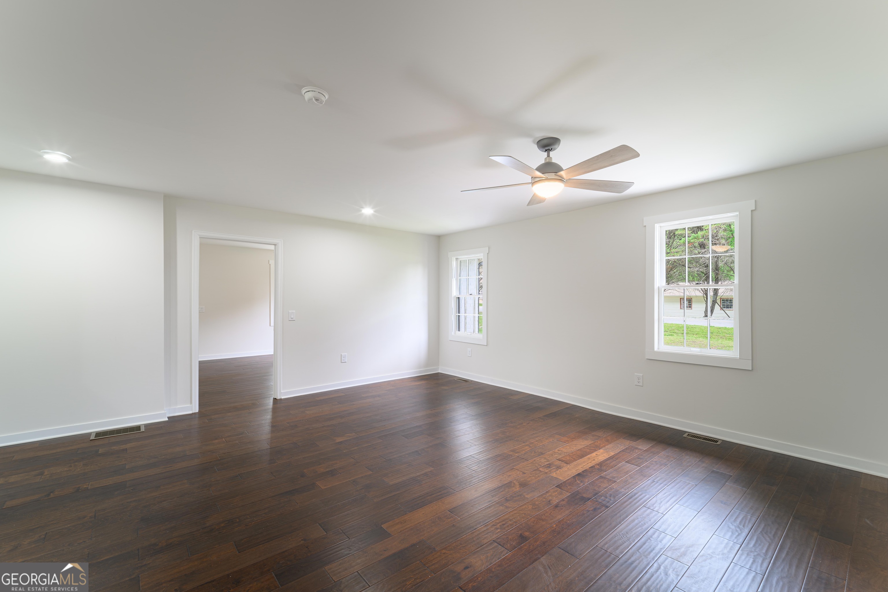418 Lamb Road Moreland, GA 30259 - Photo 12 of 32 a view of an empty room with wooden floor and a ceiling fan